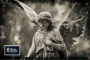 Gray-tone photo of an angel statue looking down