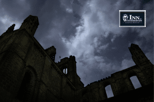 Silhouette of an old hospital building against a cloudy dark blue sky