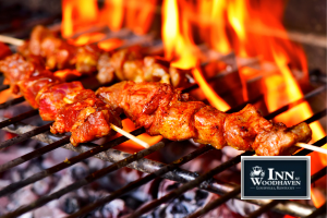 Chicken skewers over an open flame on a charcoal grill