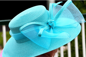 A fancy blue, wide-brimmed woman's hat with a large blue bow for the Kentucky Derby