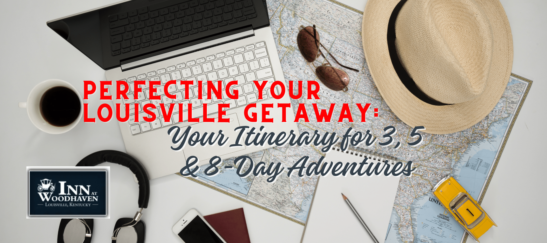 A laptop, tan hat, headphones, and map on a white desk.