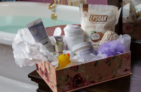 box of bath products containing salts, lotions, a loofah and a rubber duck